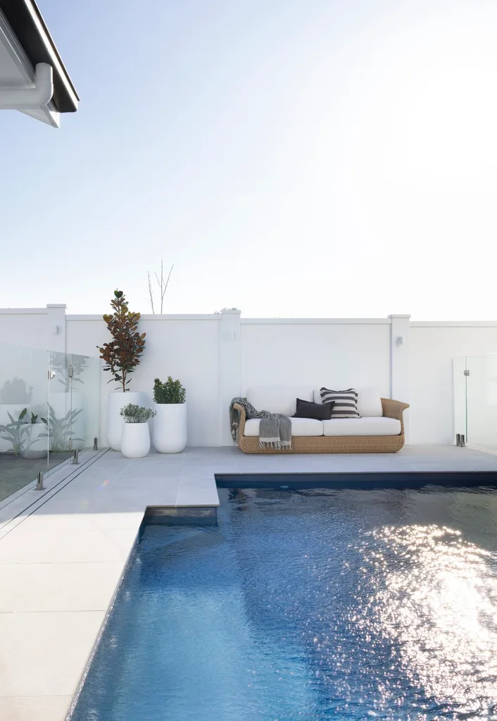 A pool area with a white fence.