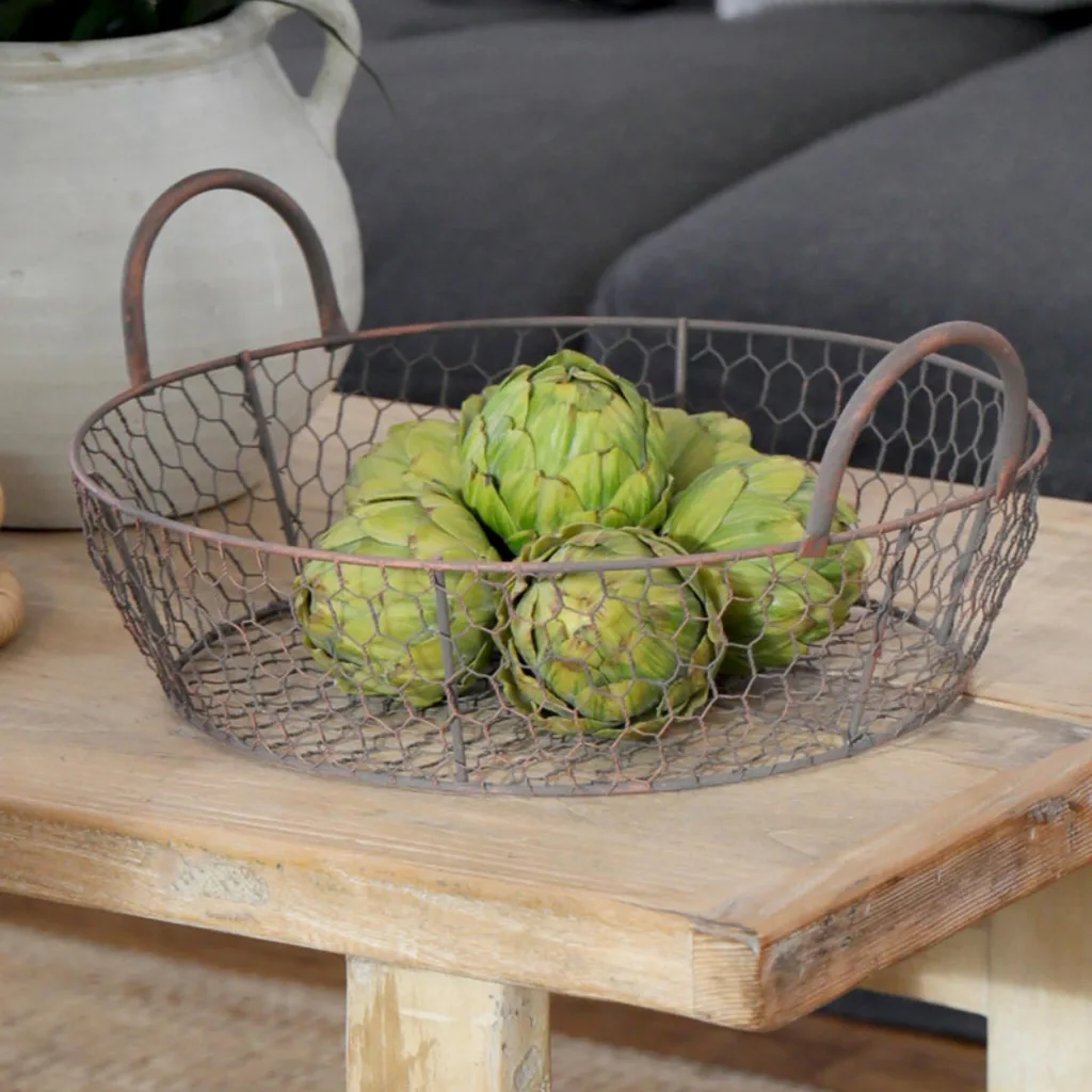 rustic wire basket with raw artichokes