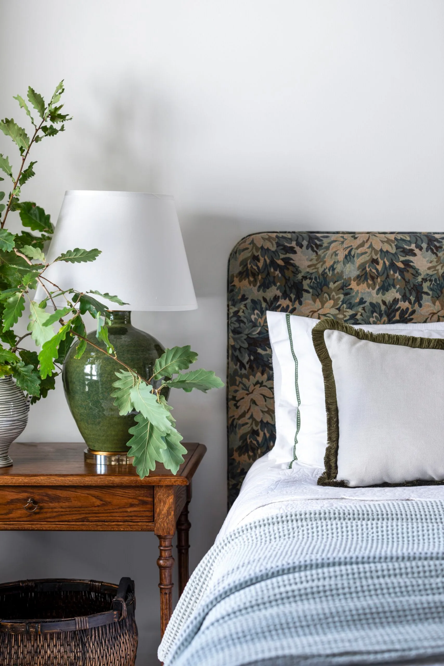 A bedroom with a patterned bedhead. 