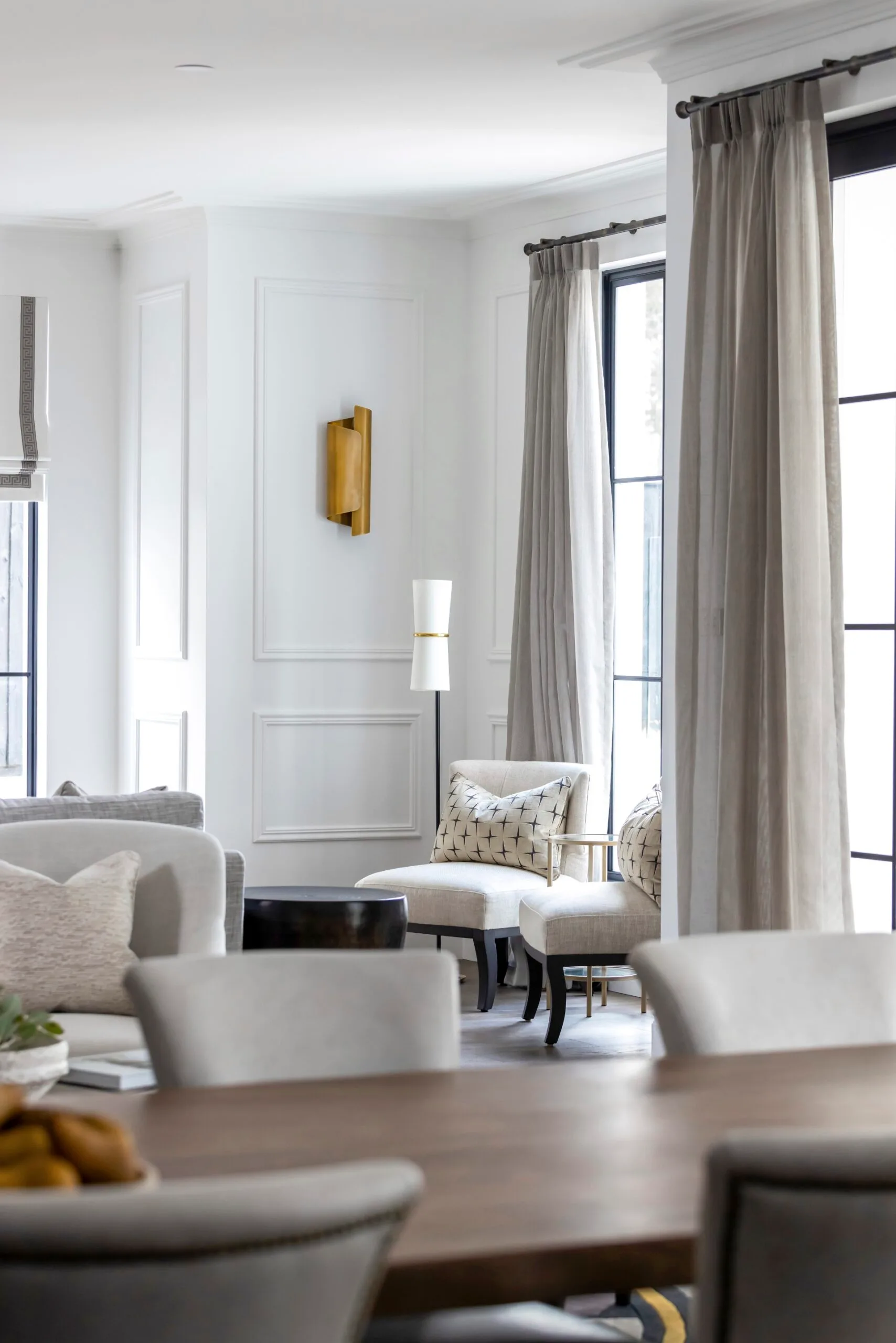 Coco Republic Interior Design Masterclass living room armchairs with brass wall sconce and sheer curtains