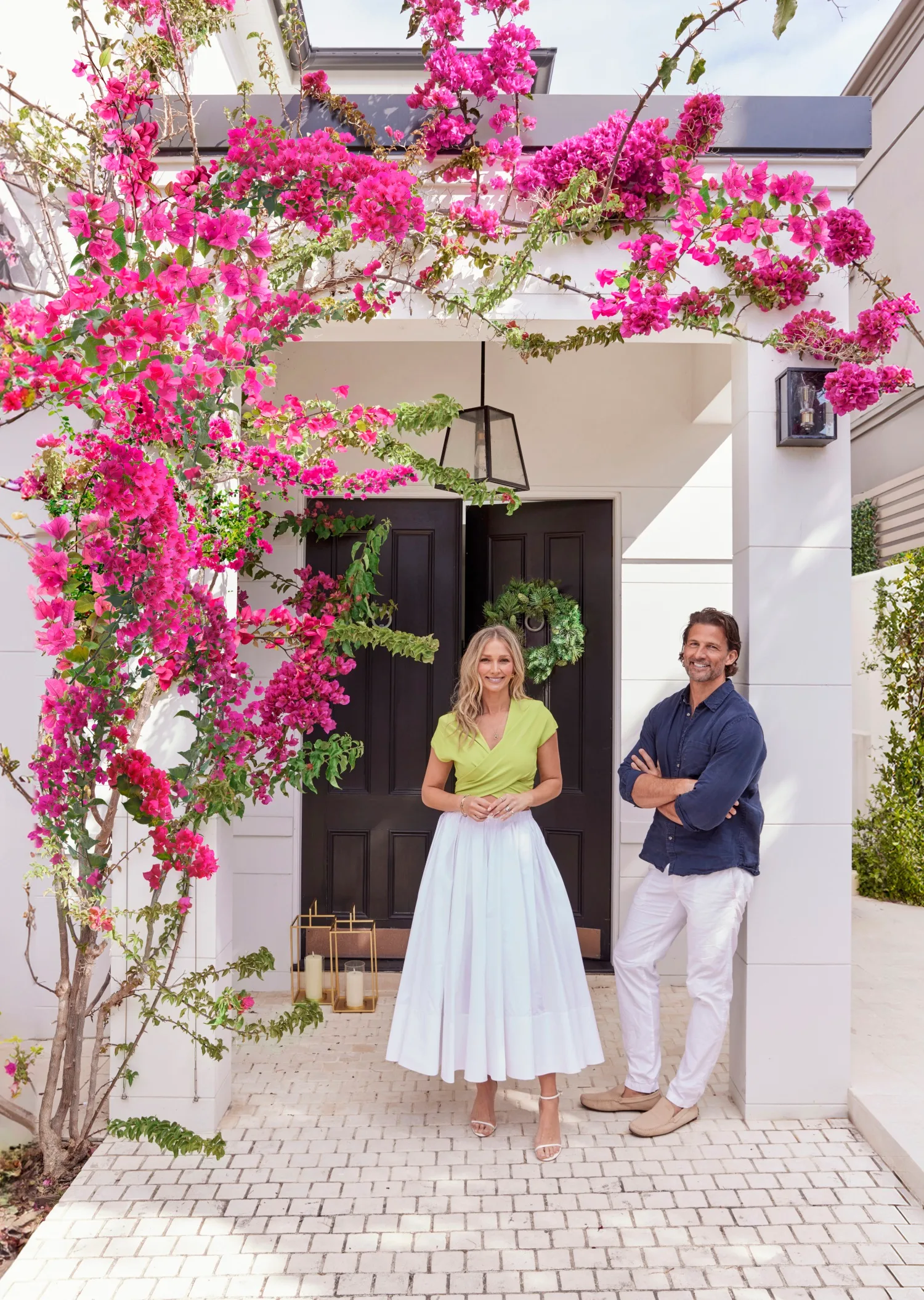 Tim and Anna Robards outside their home with bougainvillea framing the entry