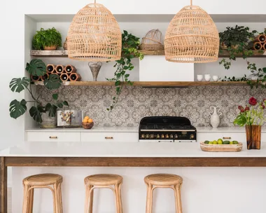 Kitchen with white walls, white joinery, reclaimed timber open shelving and patterned tile splashback.