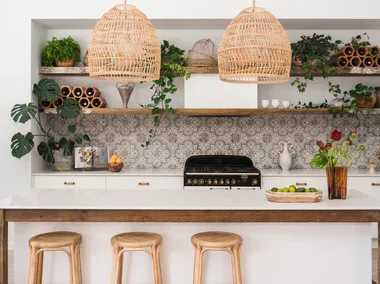 Kitchen with white walls, white joinery, reclaimed timber open shelving and patterned tile splashback.