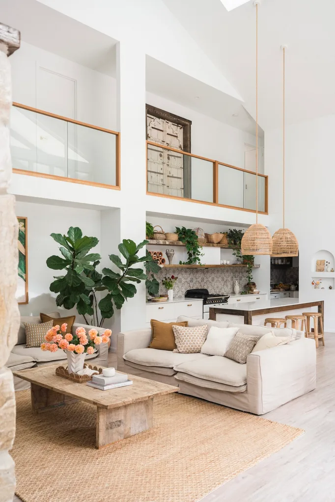 An open plan living room and kitchen positioned beneath an open hallway on the second floor of the home.