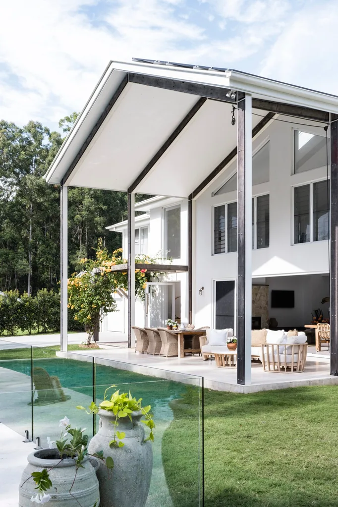 A white house with a vaulted ceiling above the alfresco dining and living area.