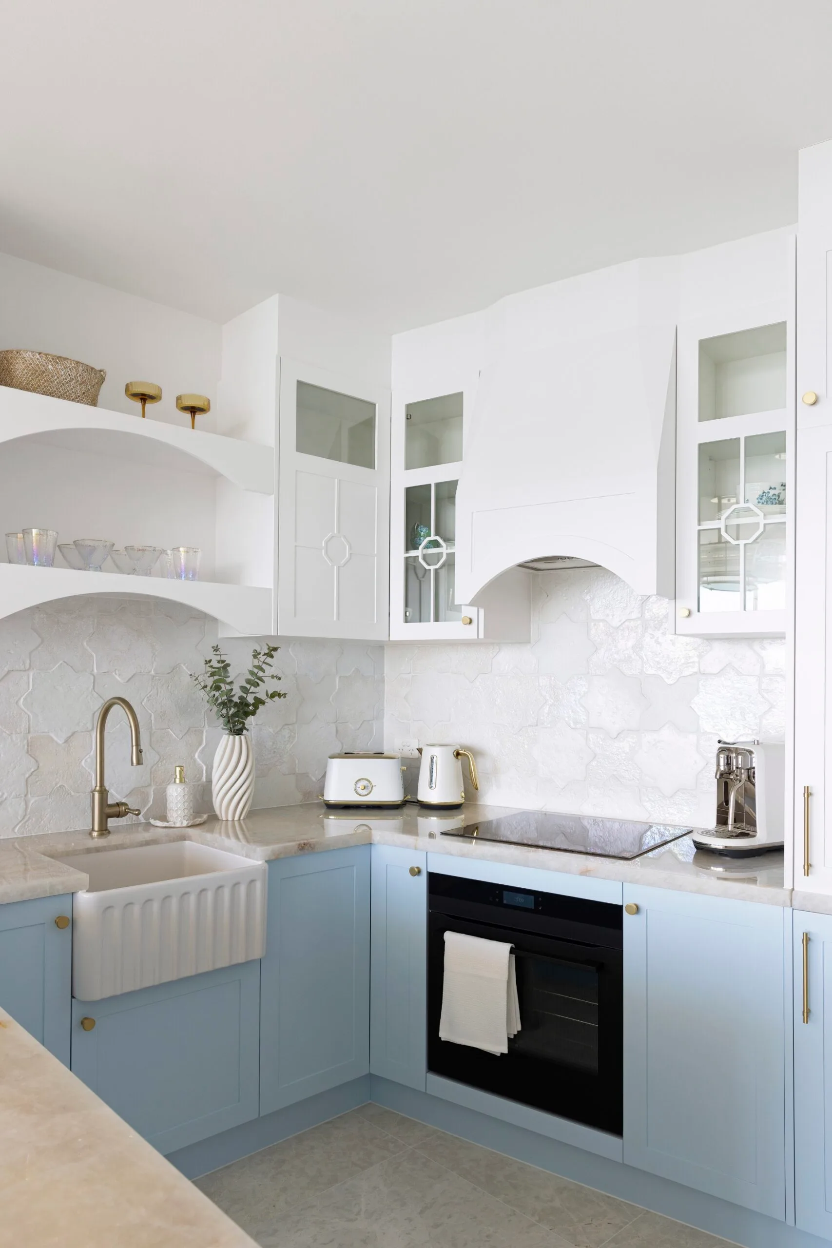 A white kitchen with blue base cabinetry.