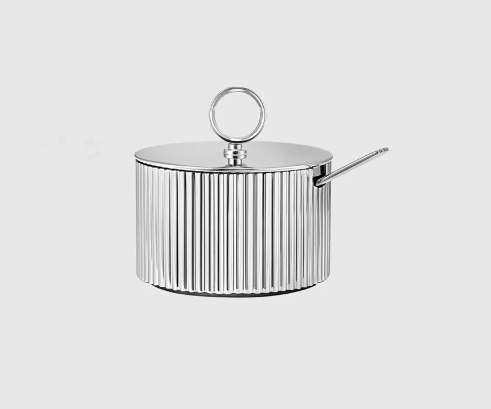 A silver sugar bowl with spoon