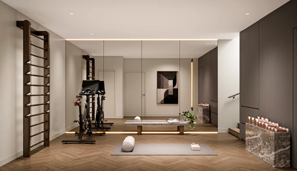 A home gym with a mirror covering the length of a wall, an exercise bike, yoga mat and rose gold weights.