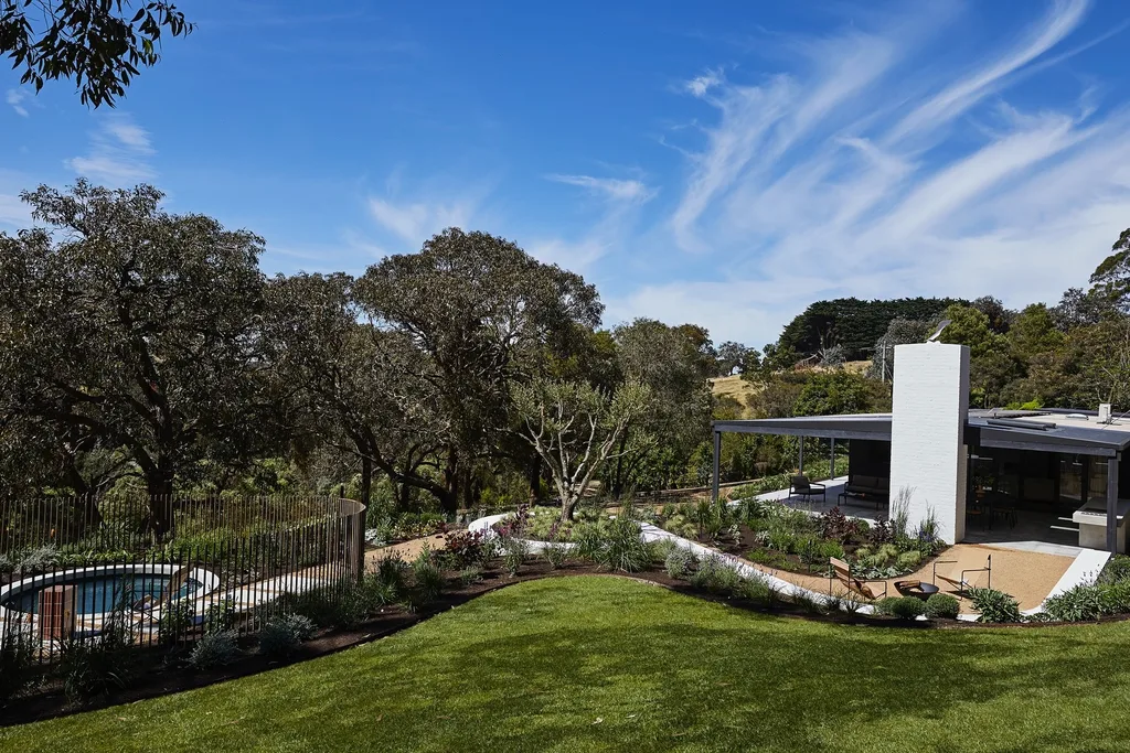 The outdoor area of Bec Judd's Arthurs Seat house, complete with a circular pool and rolling hills in the background.