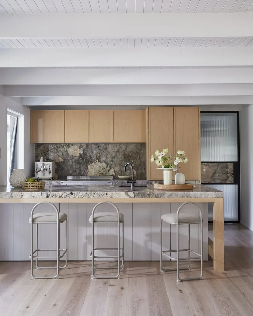 The kitchen has oak flooring, timber veneer joinery and marble benchtops.