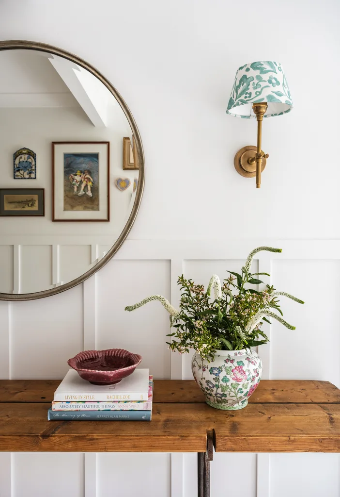 Round mirror over table and wall light