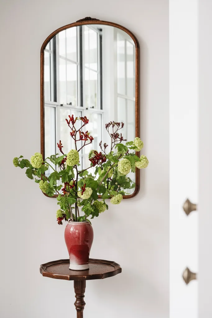 Red vase with flowers on side table