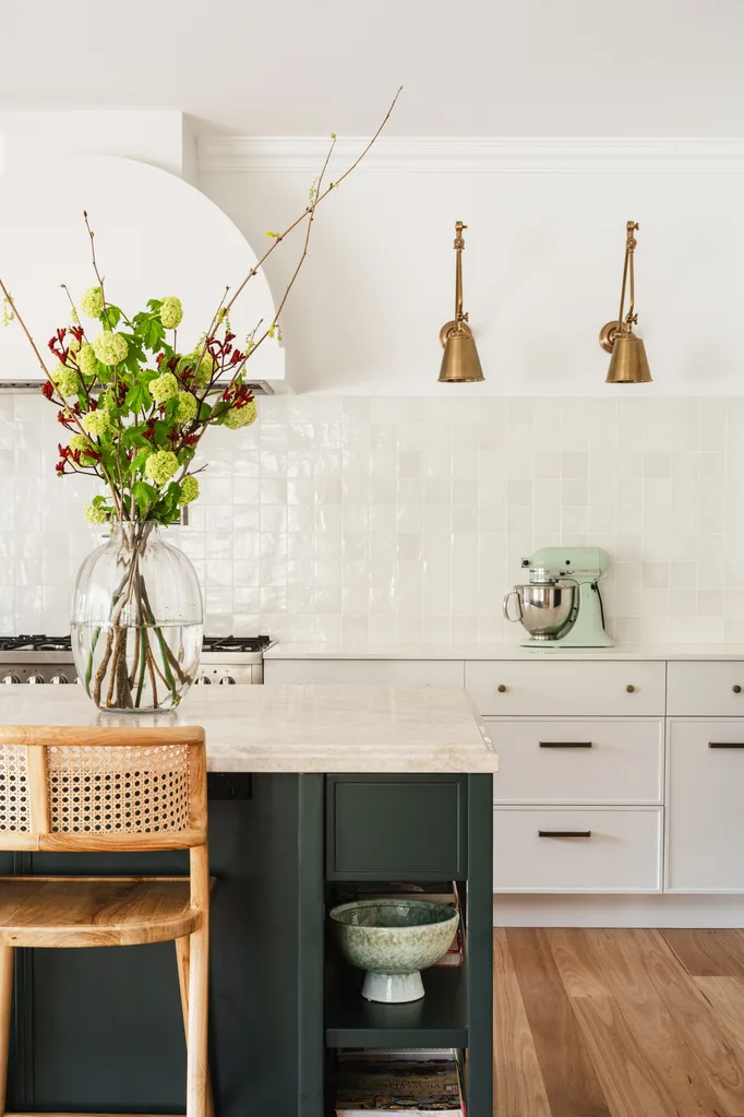 White kitchen with dark island base and large vase