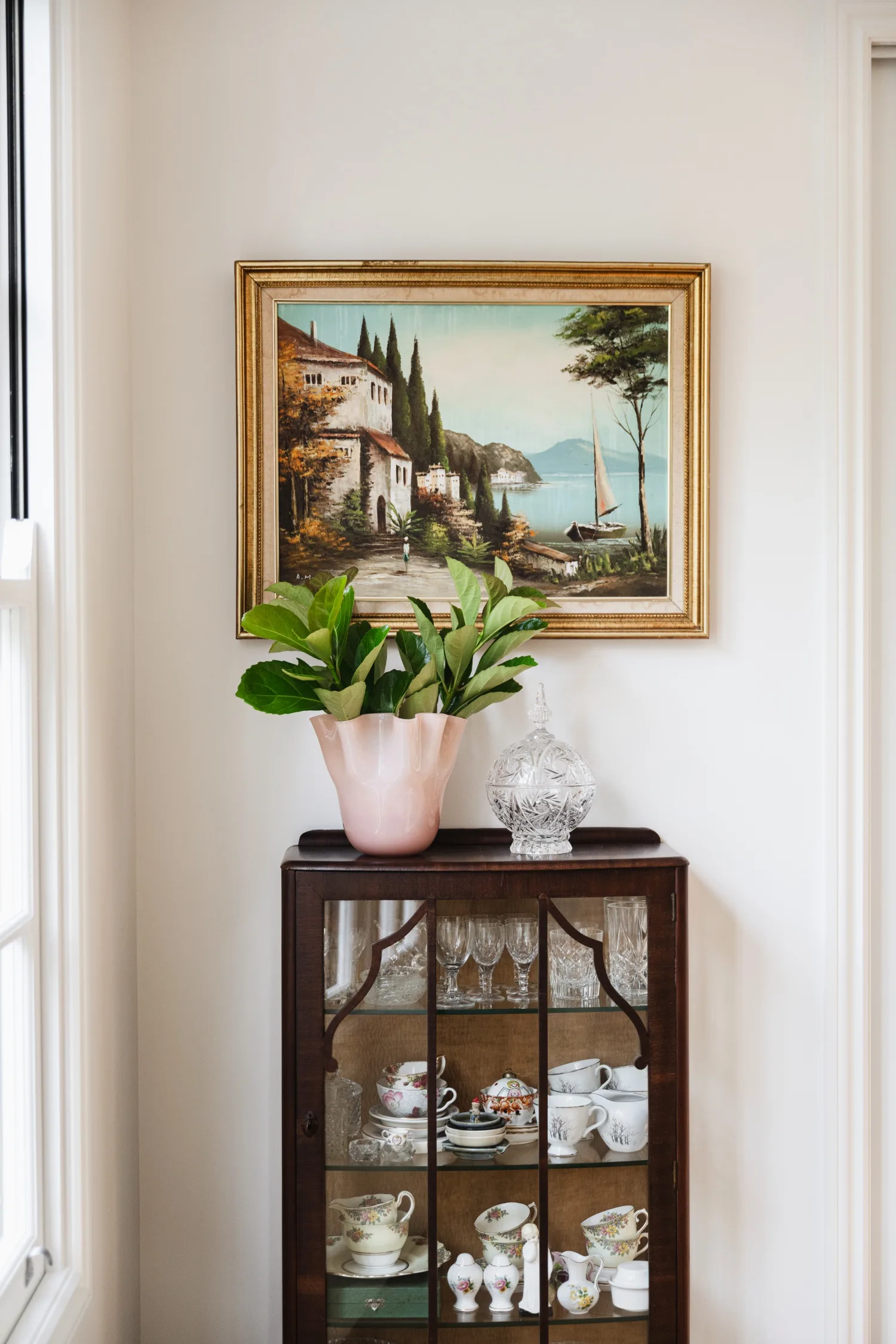 Vignette with artwork and pot on cabinet