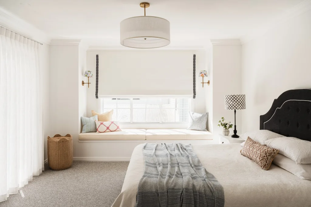 Bedroom with throw on bed and large round white pendant