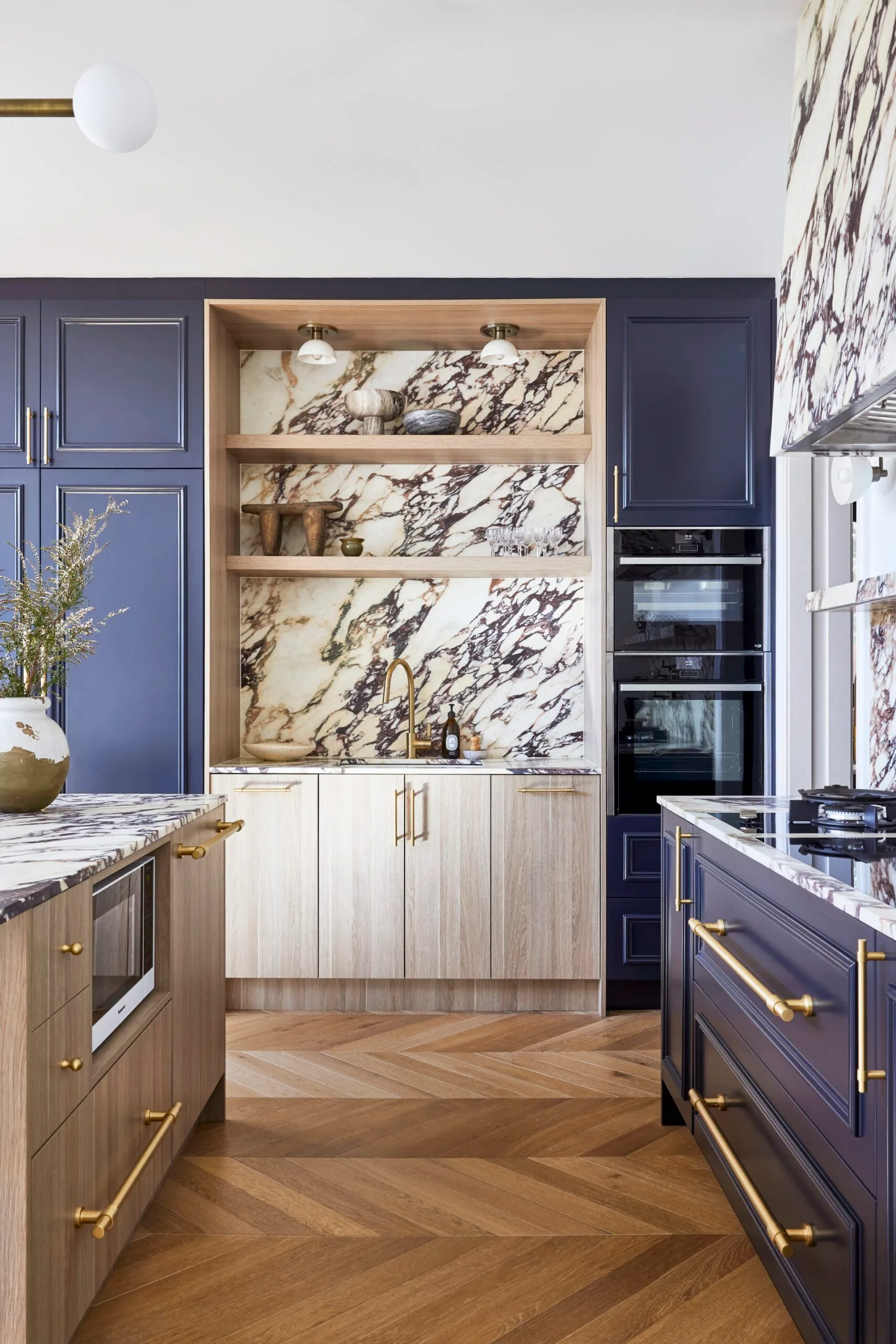 Californian bungalow renovation kitchen with calacatta viola marble, navy cabinets, brass hardware and chevron oak floors