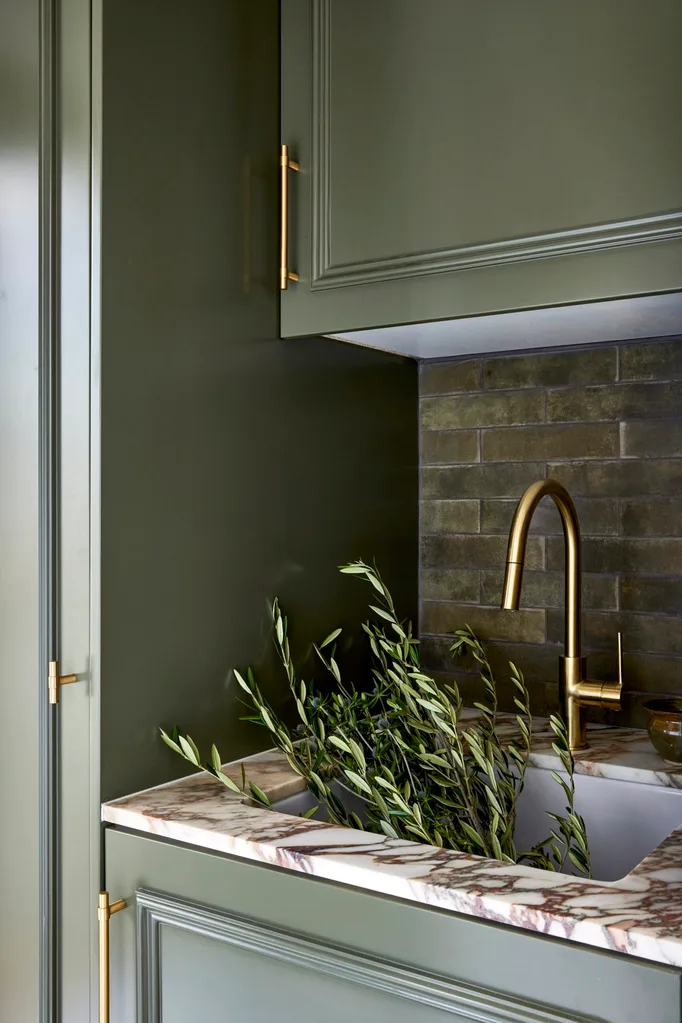 Californian bungalow renovation laundry mudroom with cabinetry painted in green dulux mangrove with a marble benchtop and brass tapware