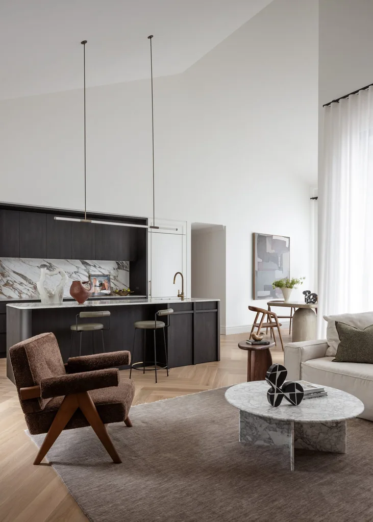 Kitchen and living featuring a brown armchair, marble coffee table and light brown rug
