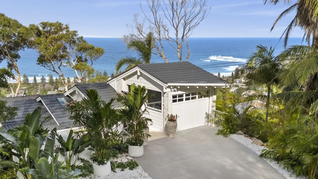 Mitch and mark from the block's newport white hamptons-style house is for sale featuring a front garden, garage and ocean views