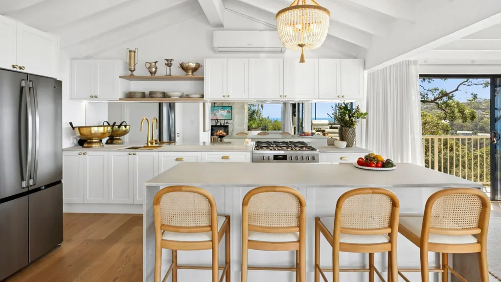 Mitch and mark from the block's newport house sale featuring
a white hamptons kitchen, timber barstools, raked ceiling and a mirrored splashback