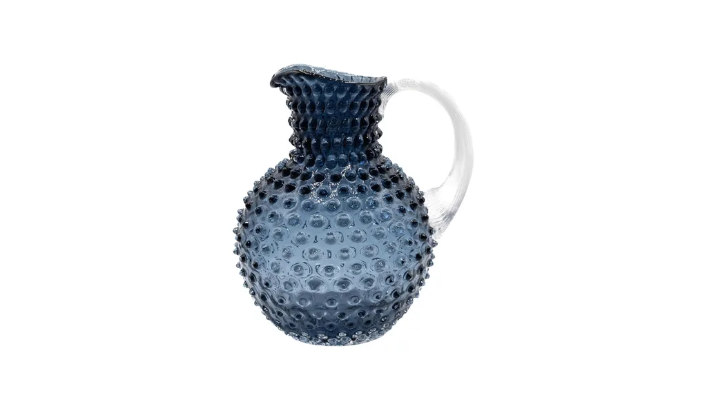 A blue glass jug with ribbed detailing.