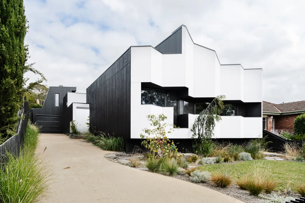 The black and white exterior of a certified passive house as seen from the street.