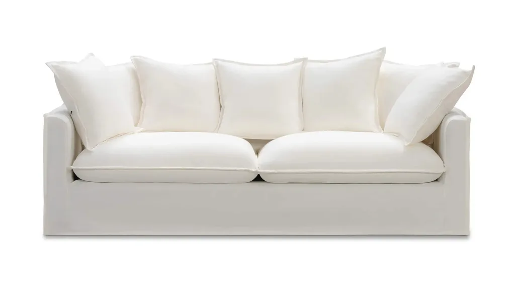 A white fabric couch with cushions from Lounge Lovers.