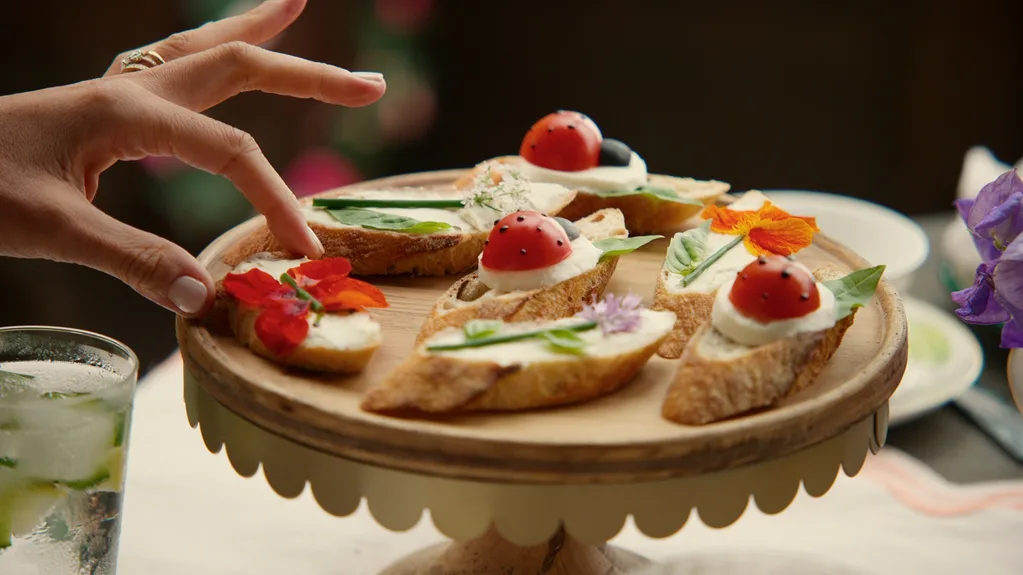 Slices of bread with produce arranged into ladybugs and flowers
