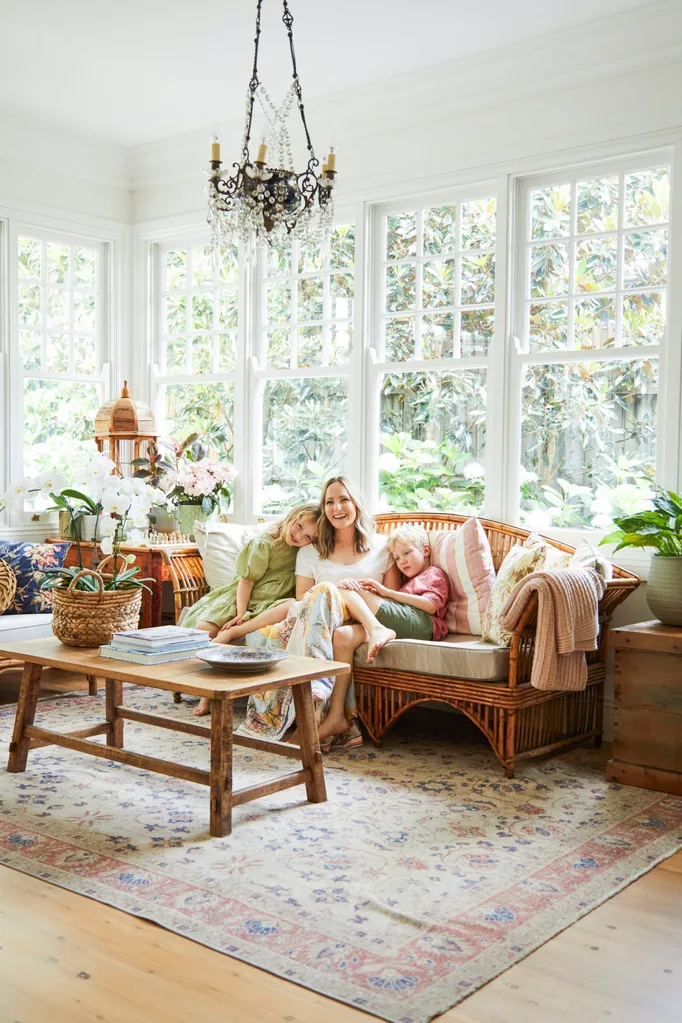 alexandra nea's eclectic vintage country home's living room with a chandelier, timber coffee table and persian rug