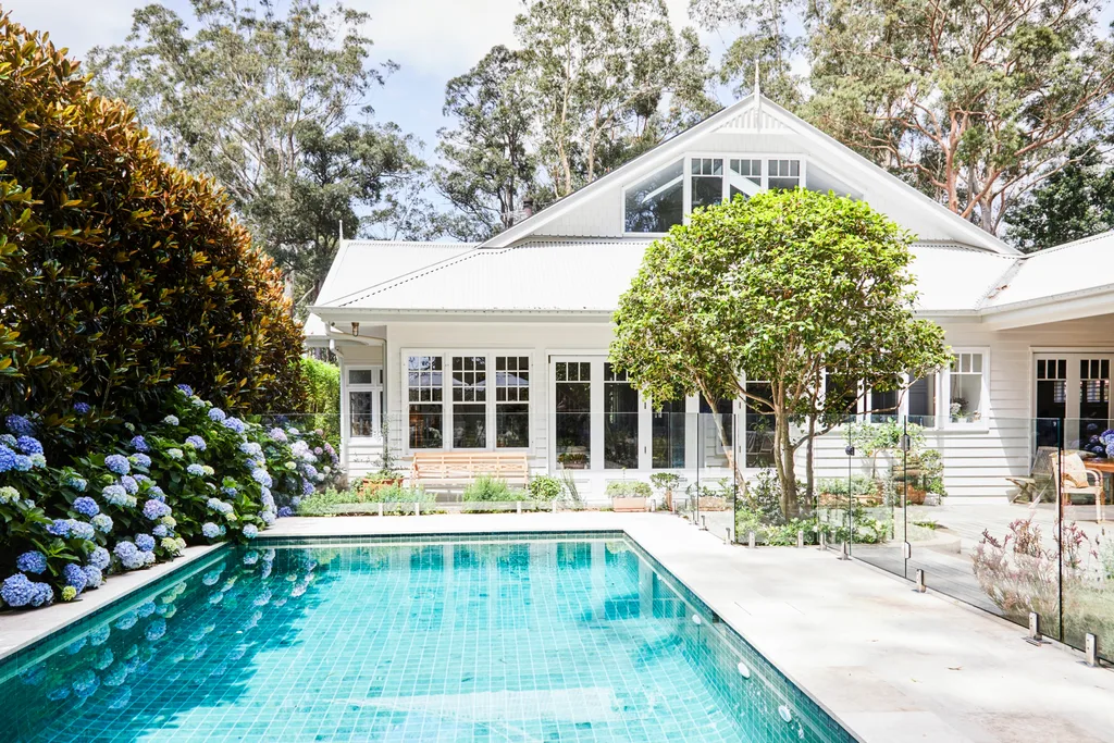 alexandra nea's white weatherboard house and colorbond roof, with a backyard pool and garden featuring heirloom hydrangeas