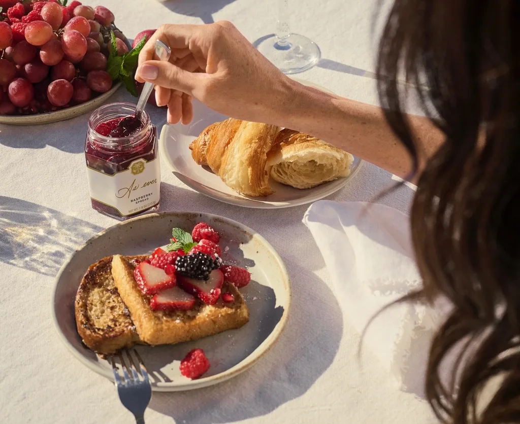 Meghan getting jam out of a jar with toast next to it