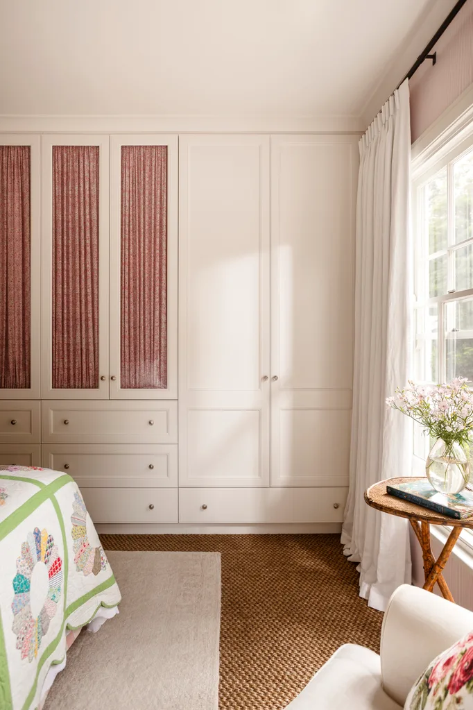Close up of kids bedroom white cupboards with pink fabric details