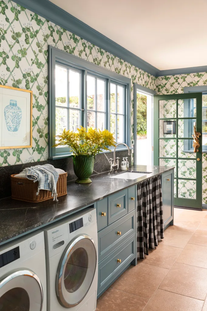 Laundry with blue cabinets and floral wallpaper