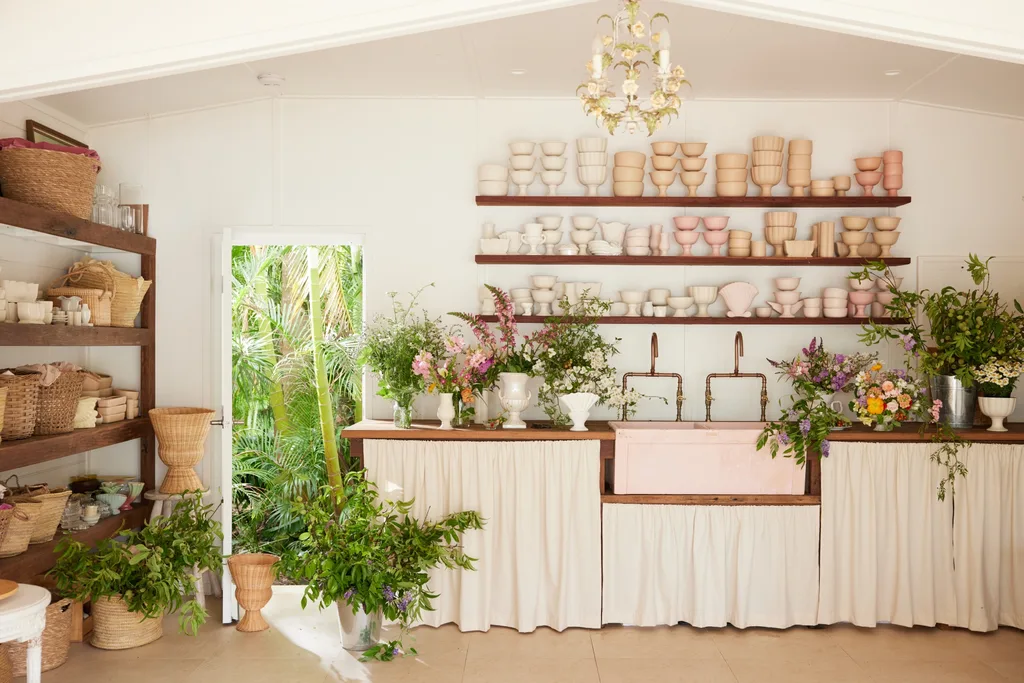 Tanya Barbariol of Oh Flora in Byron Bay in her florist studio and store, featuring a pink sink and ceramic vessels on the shelf