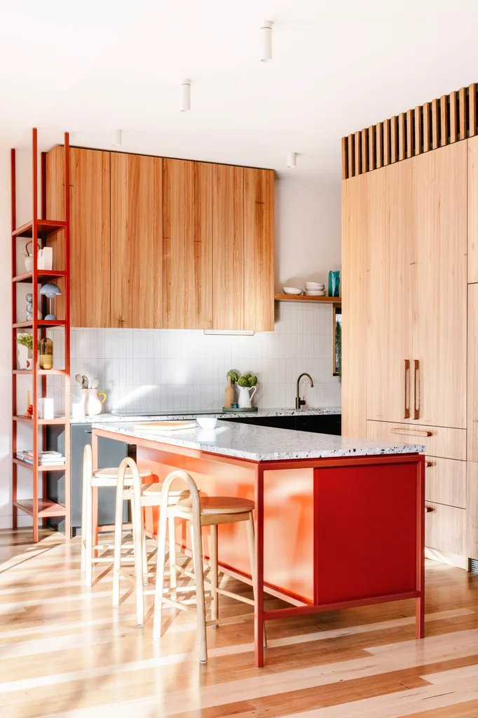 A timber kitchen with a red kitchen island.