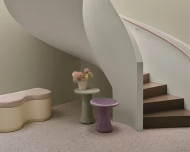 Curved staircase and soft purple and green coloured tables