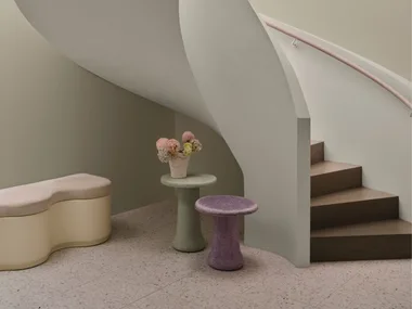 Curved staircase and soft purple and green coloured tables