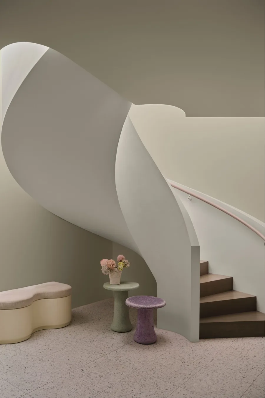 Curved staircase and soft purple and green coloured tables