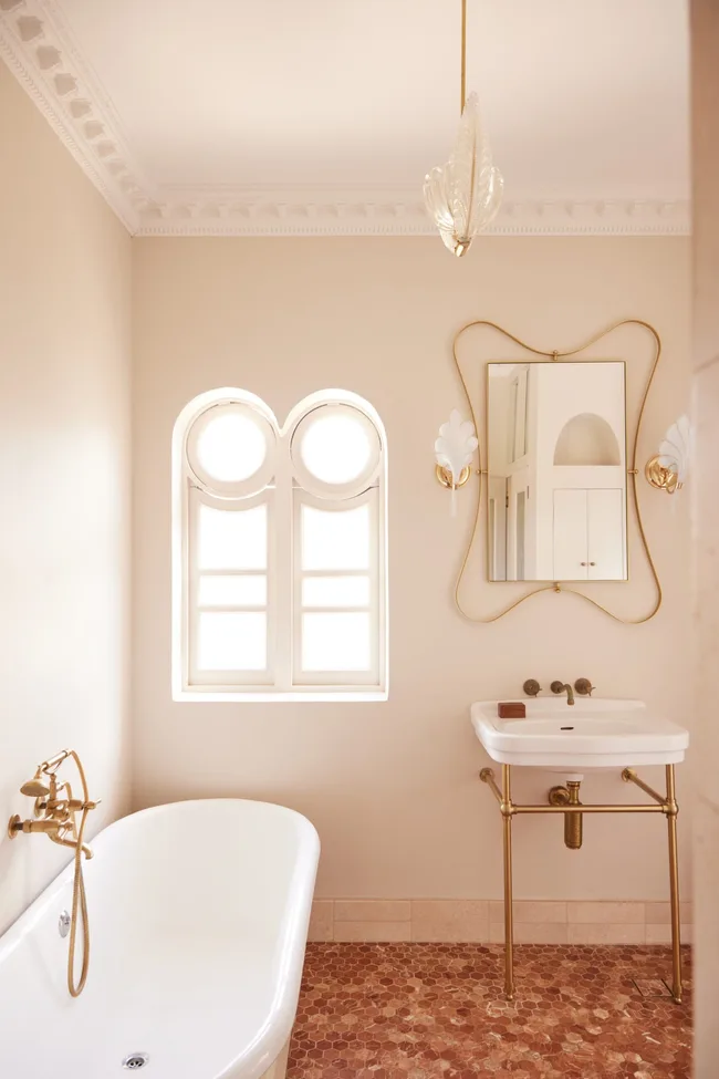 An art deco style bathroom including a freestanding Turner Hatings basin with gold hardware.