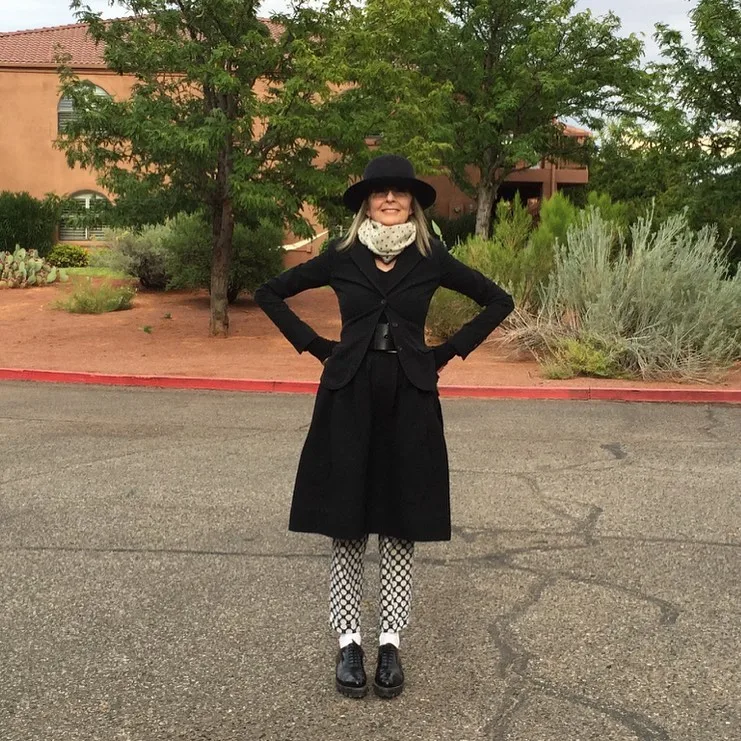 Diane Keaton with her hands on her hips on the street