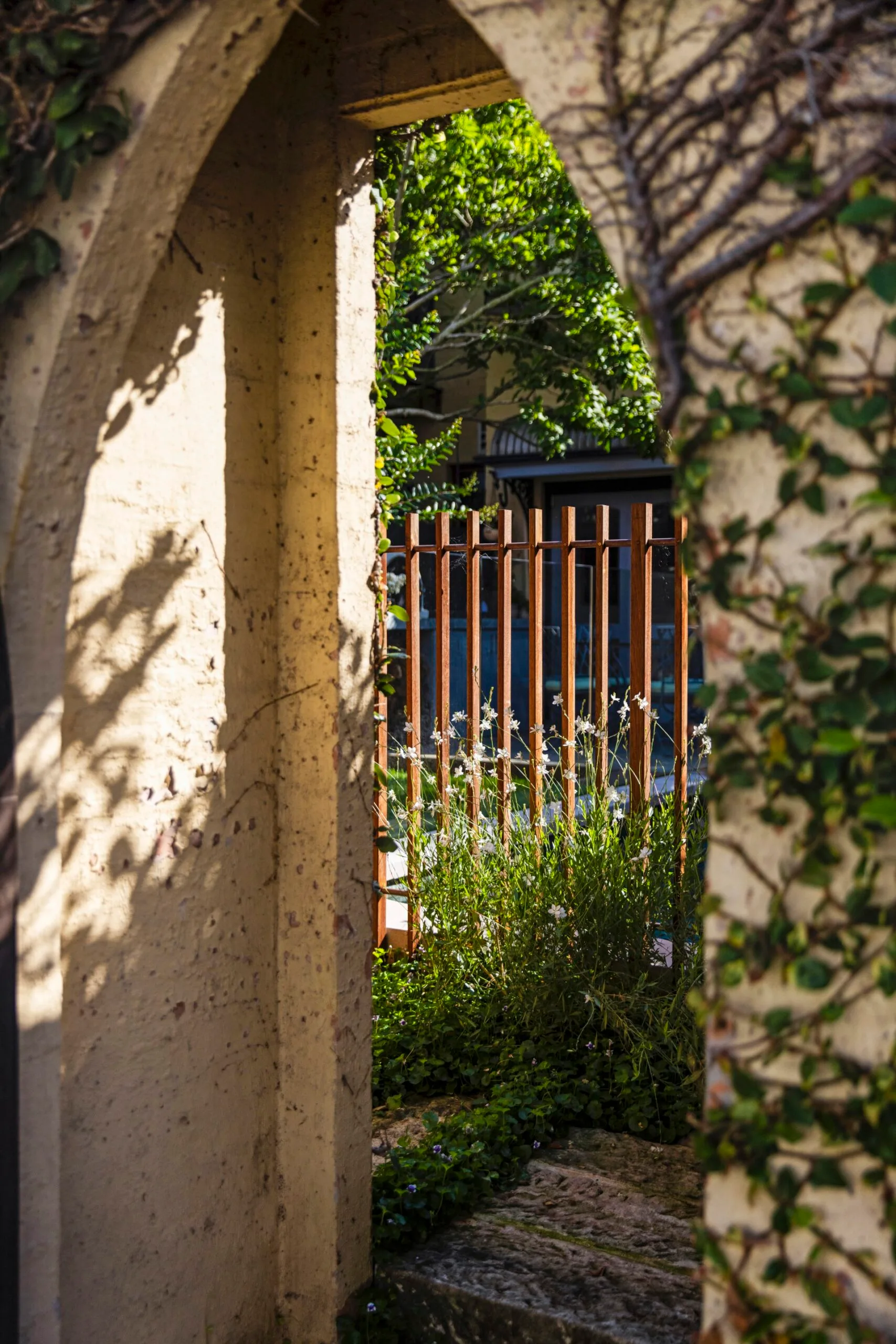 An arched wall in a garden. 