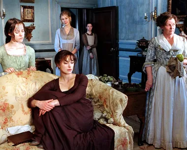 A still from the 2005 Pride and Prejudice movie, with the Bennet sisters and Mrs Bennet in the living room of their home.
