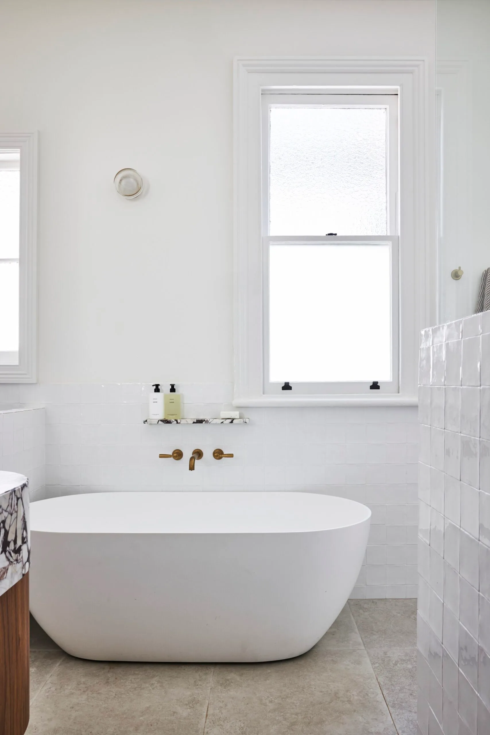 A white bathroom which showcases small bathroom design ideas, such as reserved use of tiles.