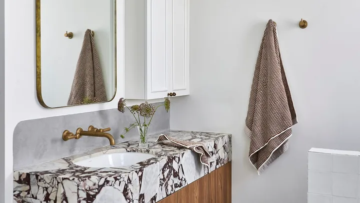A white bathroom which showcases small bathroom design ideas, such as recessed storage.