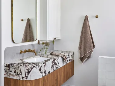 A white bathroom which showcases small bathroom design ideas, such as recessed storage.