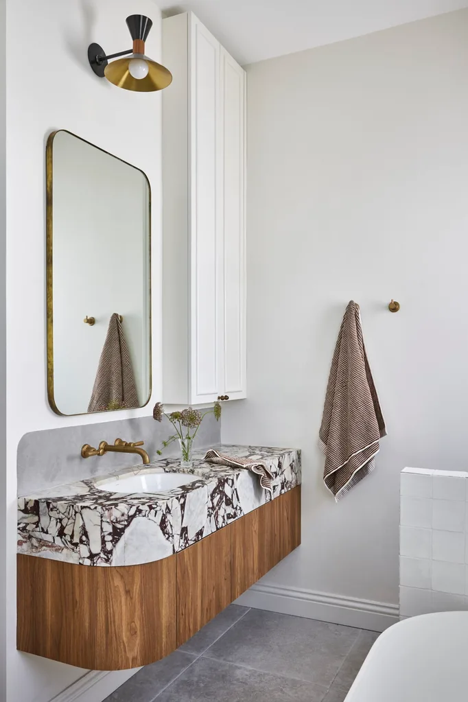A white bathroom which showcases small bathroom renovation ideas, such as recessed storage.