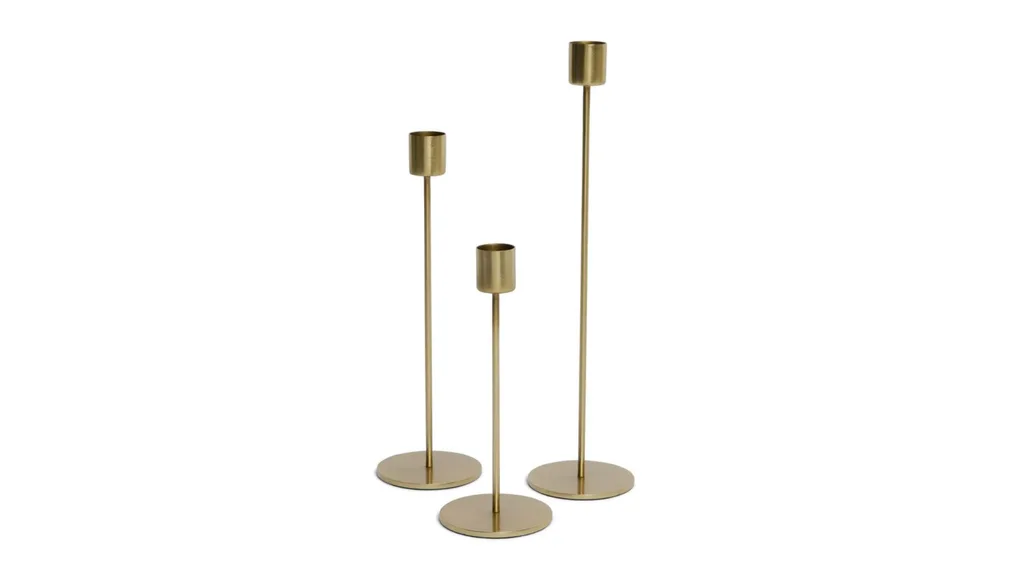 Three brass candlesticks of varying heights with round bases.