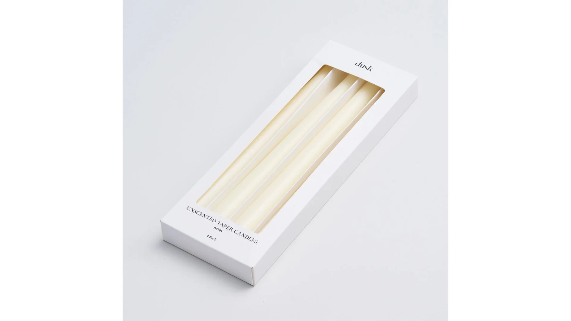 A set of four ivory unscent taper candles