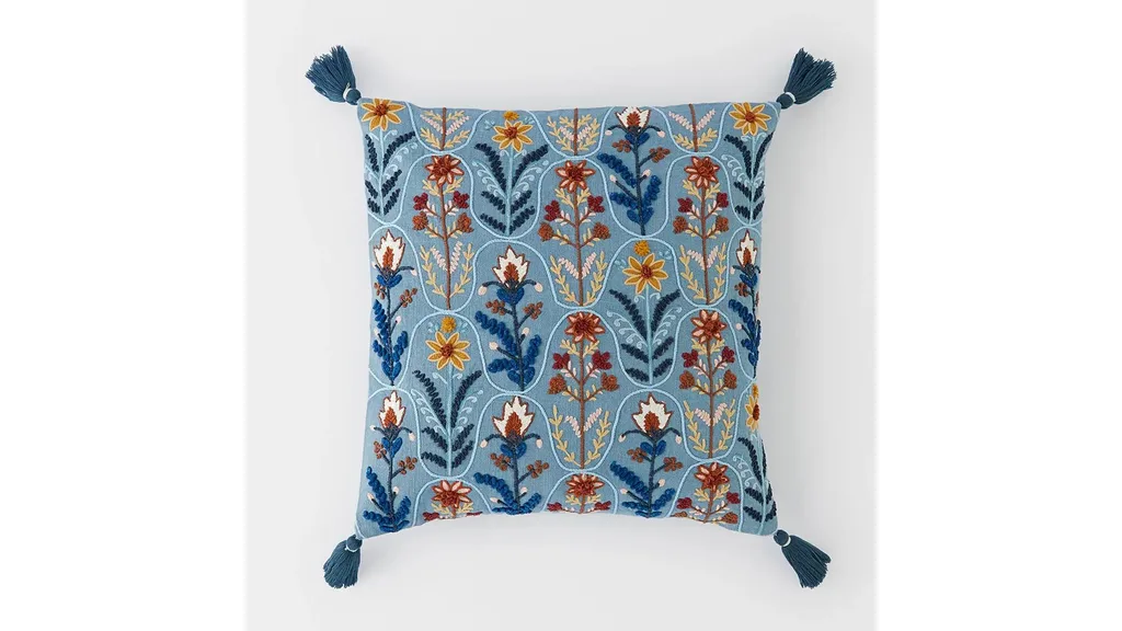 A blue patterned cushion with tassels on the corners, perfect for winter decorating
