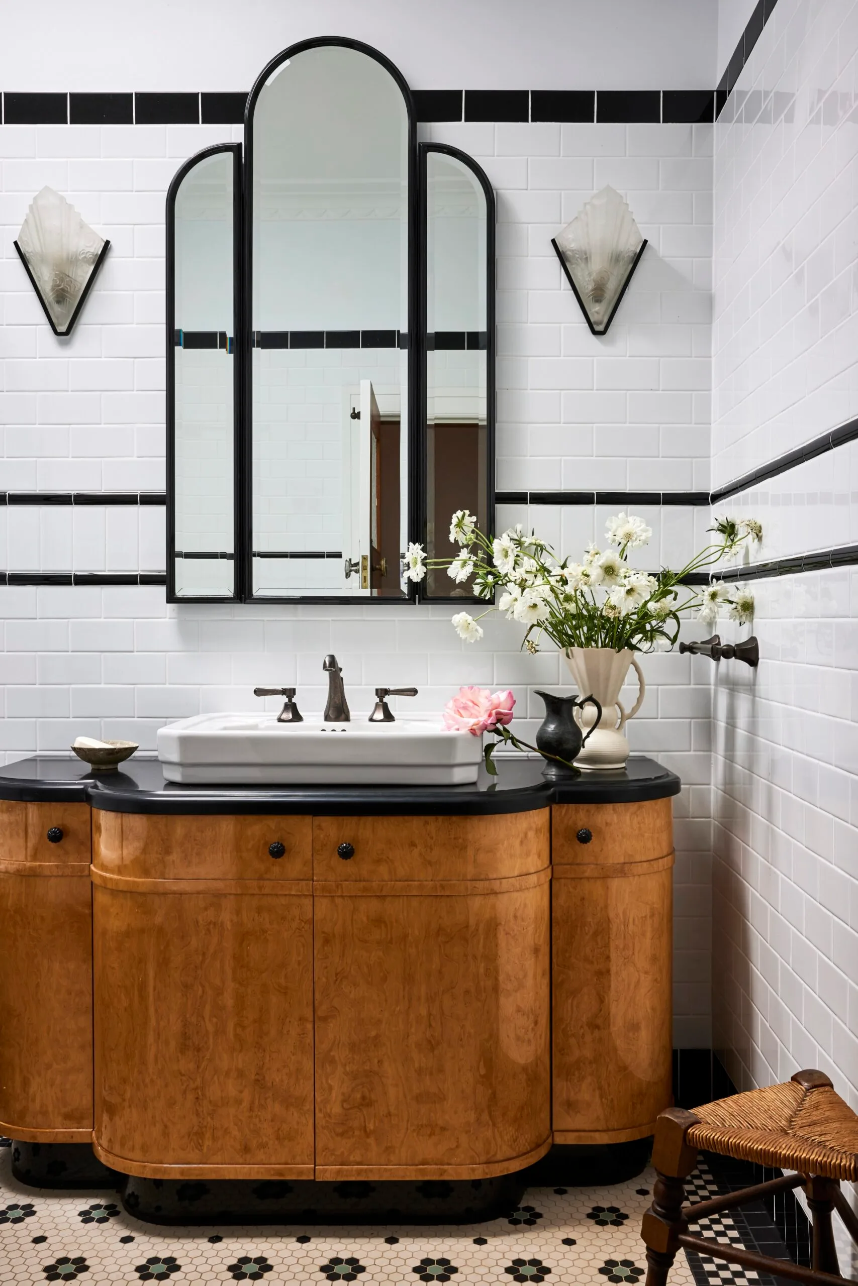 A timber vanity and art deco mirror in a 1920s inspired bathroom. 